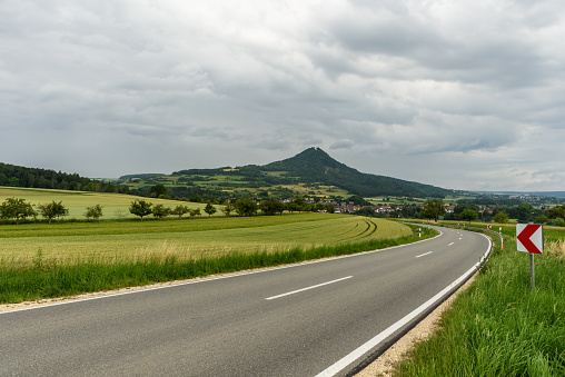 Country road leads through green, hilly landscape in Hegau, , Weiterdingen, Baden-Wuerttemberg, Germany
