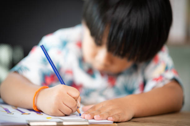 istock asian Little boy writing in book at desk 1333515564