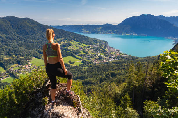 Young caucasian woman standing on lookout Sankt Gilgen near hill Schafberg with Attersee, Austria Young caucasian woman standing on lookout Sankt Gilgen near hill Schafberg with Attersee, Austria attersee stock pictures, royalty-free photos & images