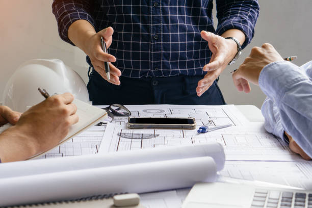 istock engineer team working in office with blue prints.Team of architects people. 1333517942