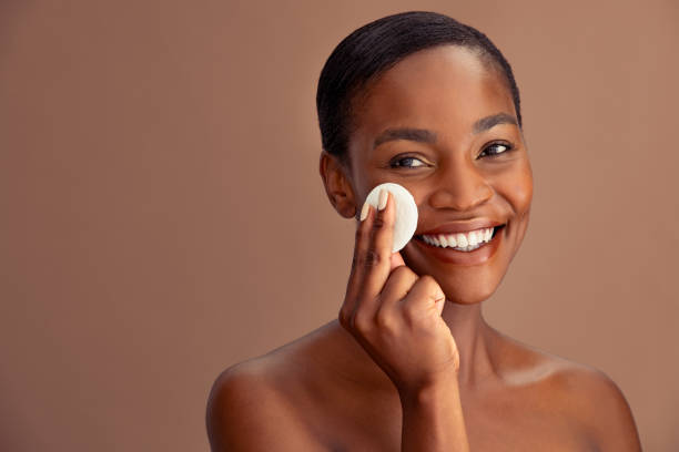 istock Black beautiful woman using cotton pad to remove make up 1333518301