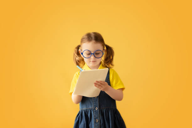 istock Child making notes. Kids dreams.Isolated on yellow background.Education background. Kid back to school. 1333519613