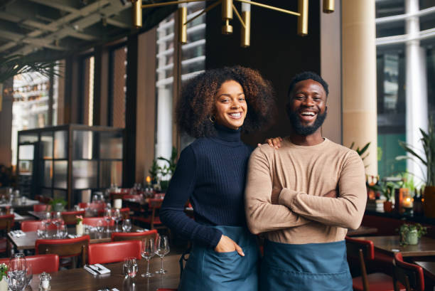 cheerful small business partners in restaurant - family business stockfoto's en -beelden