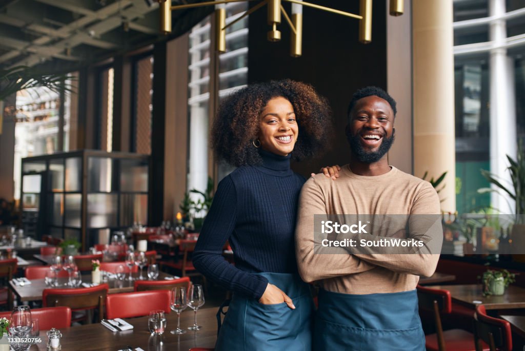 Cheerful small business partners in restaurant Owner Stock Photo