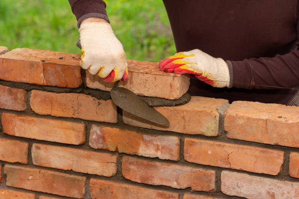 istock a man builds a wall of bricks, lays a brick on a cement-sand mortar 1333520946