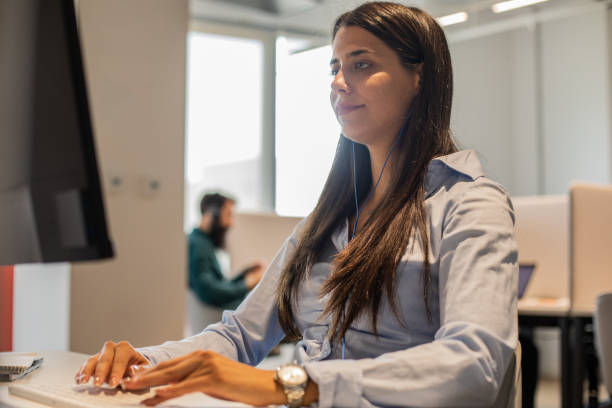 istock Young businesswoman sitting at her desk and typing data on computer 1333523086