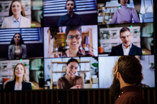 istock Man looking at shared screen on the wall during a group video call with coworkers 1333523598