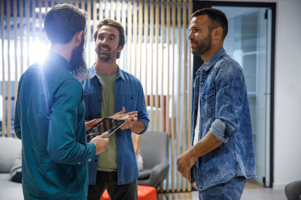 istock Three businessmen standing in the office hall, chatting 1333524657