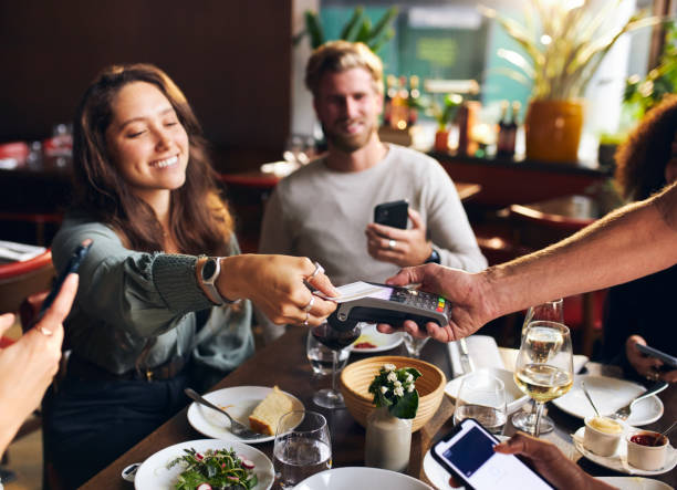 istock Woman paying with card in restaurant 1333527181