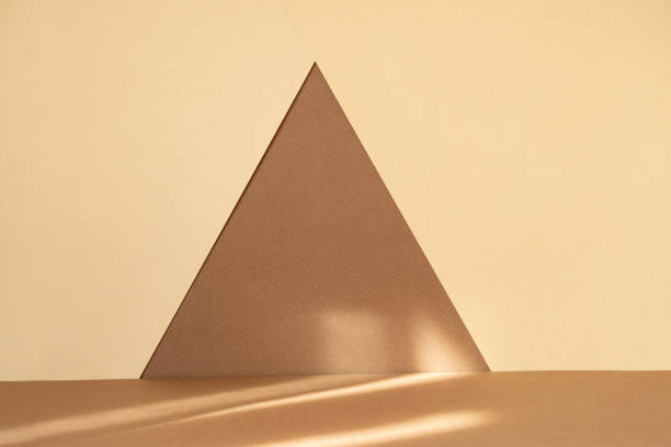 istock Abstract geometric textured background. Arbitrary triangle made of brown paper on beige surface. Ready-made mockup for advertising, beauty industry 1333527490