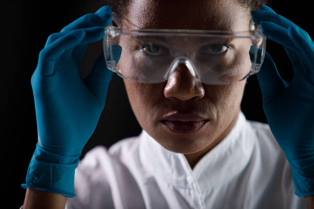 istock Female scientist looking at camera as she is putting on protective eyewear 1333528779