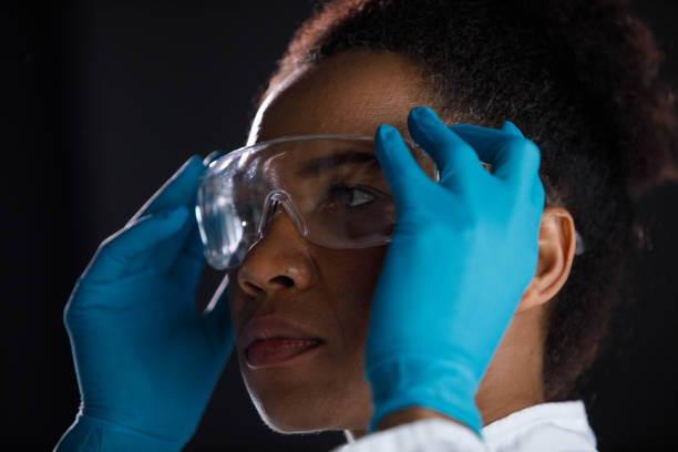 istock Serious female scientist putting on protective eyewear 1333528782