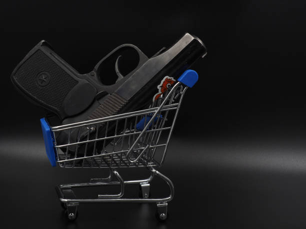uma arma preta em um carrinho de compras. - currency crime gun conflict - fotografias e filmes do acervo