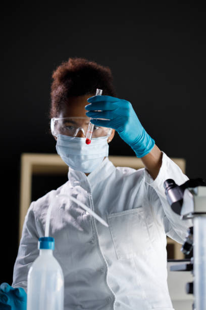 istock Female scientist analyzing a red liquid in a test tube 1333529544