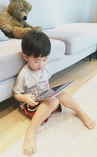 istock Asian Chinese boy playing with tablet at home 1333532571