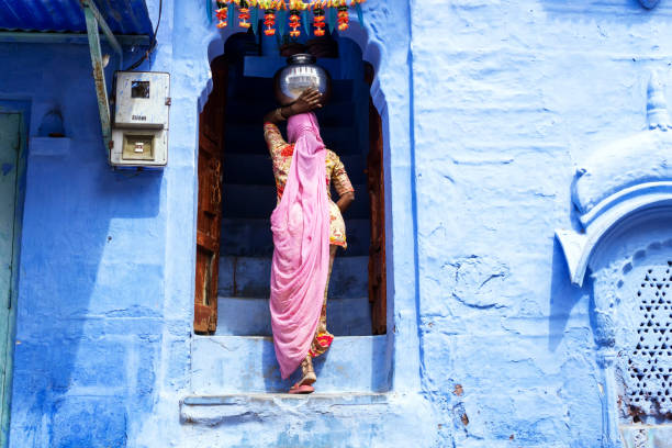 Indian woman carried water in pot on her head Jodhpur, India - 28 February, 2018: Indian woman carried water in pot on her head at Jodhpur blue city. india indian culture market clothing stock pictures, royalty-free photos & images