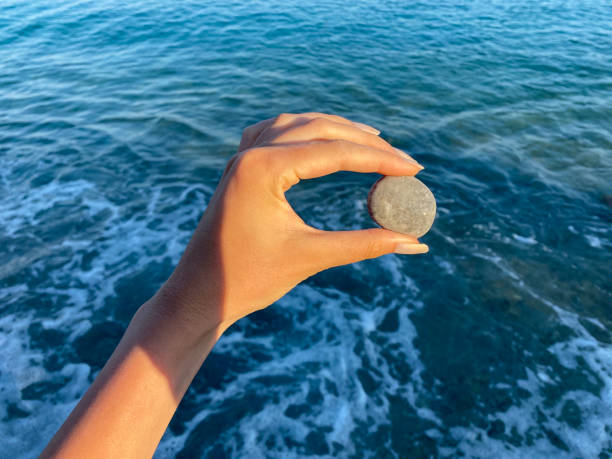 istock Holding a gray stone on the beach 1333538150