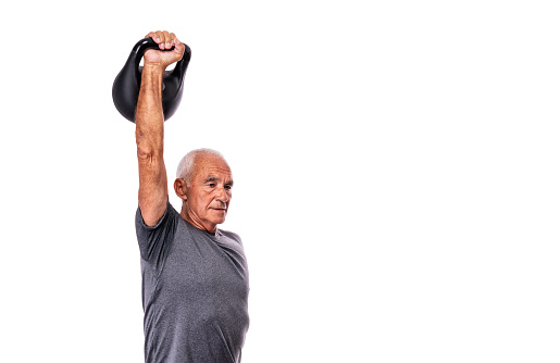 An elderly man of athletic build goes in for sports, weightlifting. Raised hand up. On an isolated white background. White background. High quality photo