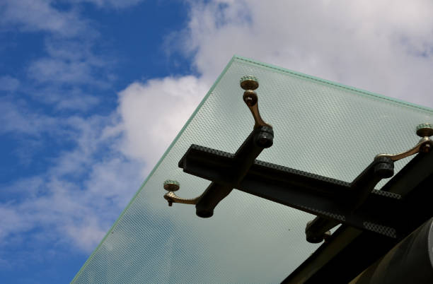 istock bus stop glazing. glass canopy attached at n several points to the metal structure. Gaps between the sky that have dots as protection against sunlight 1333542448