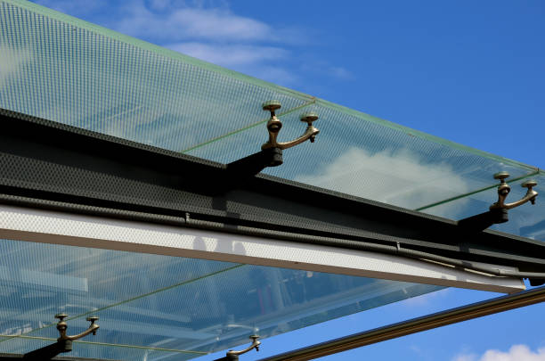 istock bus stop glazing. glass canopy attached at n several points to the metal structure. Gaps between the sky that have dots as protection against sunlight 1333543515