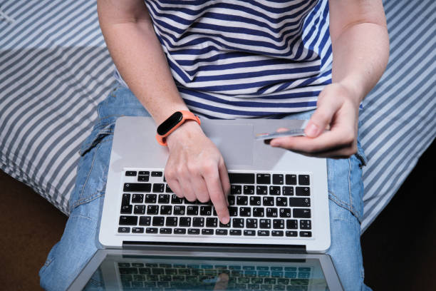 istock Person sitting on sofa is using laptop and credit card 1333543590