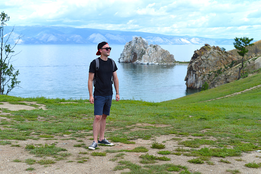 Russian tourist near holy place among shamans Shamanka. Lake Baikal, Olkhon.