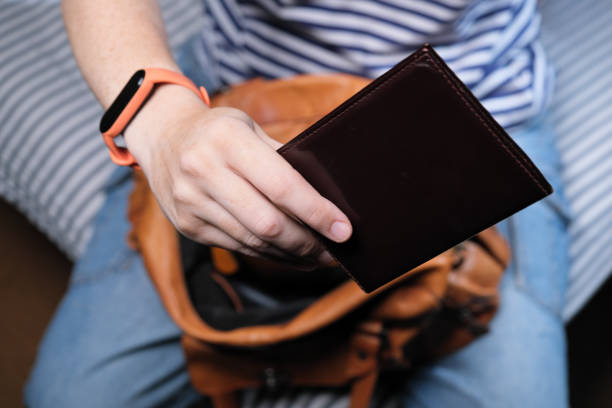 istock Woman sitting on sofa is putting documents into her purse 1333543758