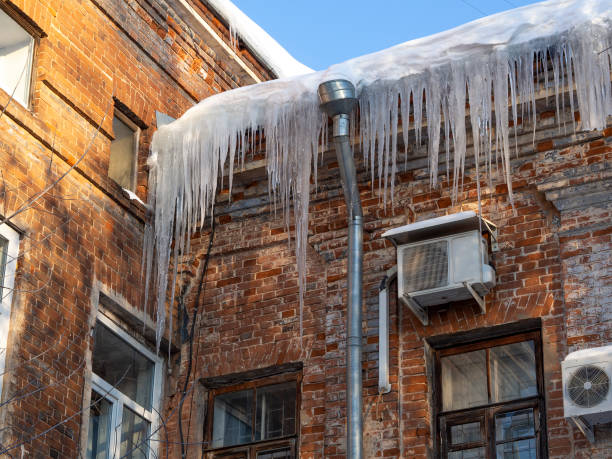 istock Icicles in sunlight hang on historic old building with a wall red damaged, dirty bricks. 1333544012