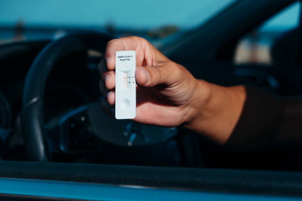 istock man in his car shows a negative covid-19 test 1333544095
