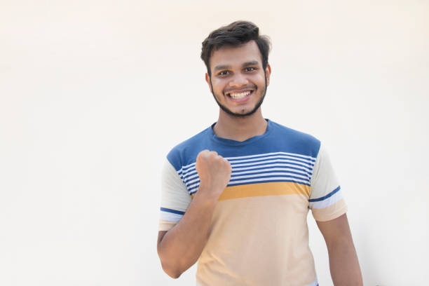 istock young man clenching fist in excitement and cheering 1333546314
