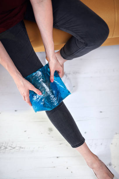 femme avec une blessure de douleur au genou à la maison en utilisant le pack de gel de glace. - ice women ice pack physical injury photos et images de collection