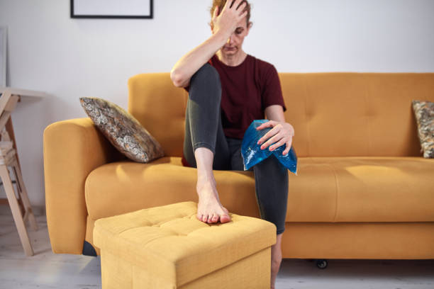 femme avec une blessure de douleur au genou à la maison en utilisant le pack de gel de glace. - ice women ice pack physical injury photos et images de collection