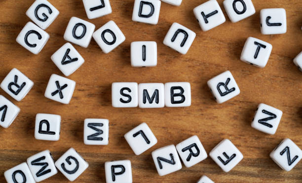 istock Tiny white and black bead cubes on wooden board, letters in middle spell SMB for Small to medium business 1333549240