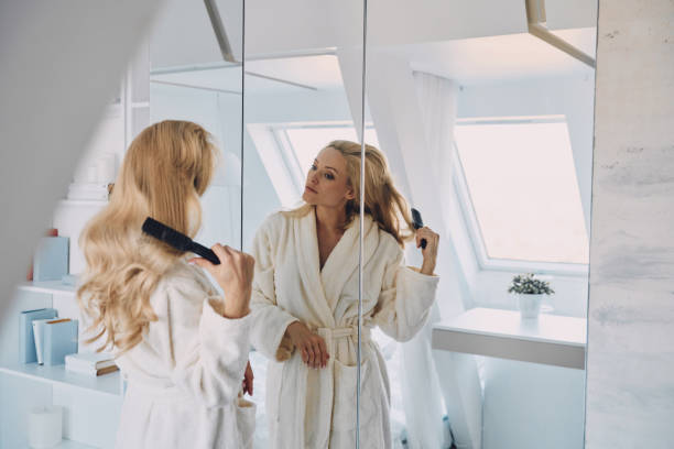 istock Attractive young woman in bathrobe combing hair 1333557891