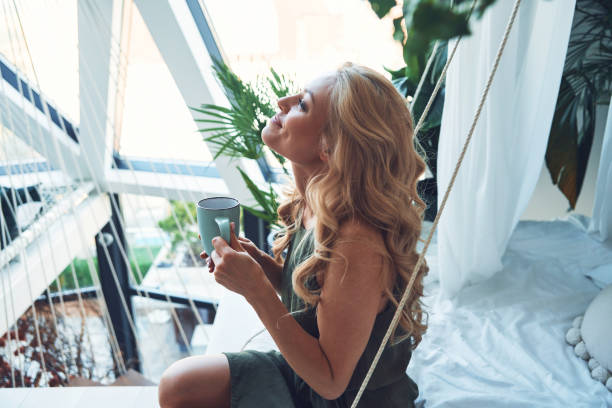 istock Attractive young smiling woman enjoying hot drink 1333558443