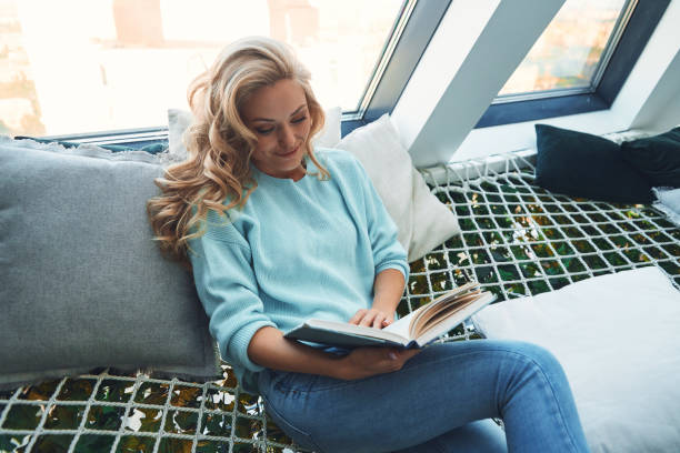 istock Beautiful young woman reading book andd smiling 1333558806