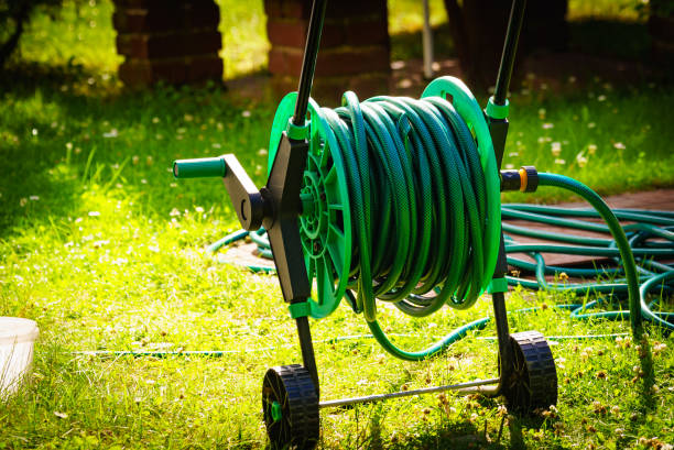 istock Garden hose for watering plants in garden 1333564152