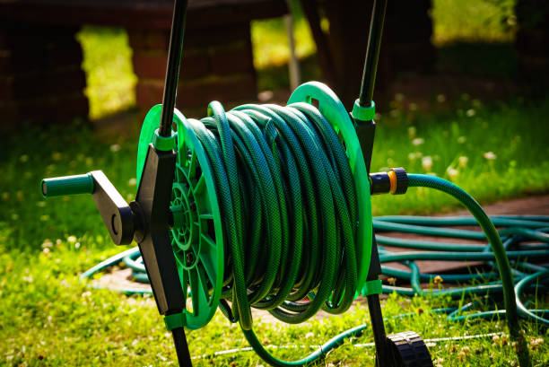 istock Garden hose for watering plants in garden 1333564372