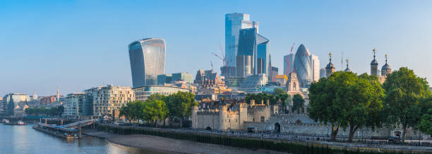 City of London skyscrapers and towers overlooking River Thames panorama City of London financial district skyscrapers illuminated by the warm light of sunrise along the River Thames, UK. bankside photos stock pictures, royalty-free photos & images
