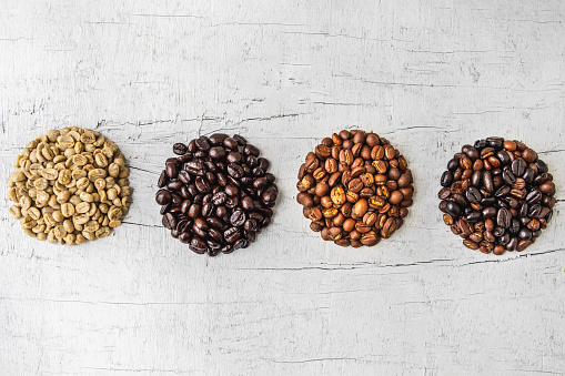 A collage of coffee beans showing various stages of roasting from green beans through to roast