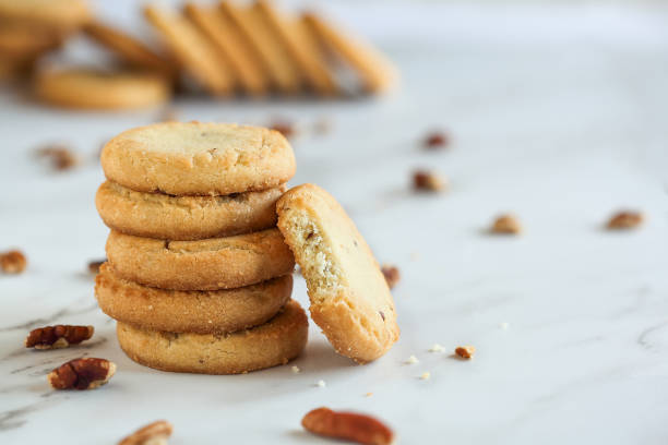 Pecan Sandies Cookies Stack of pecan sandies cookies, Sables, with one missing a bite. Selective focus with blurred foreground and background. round sugar cookie stock pictures, royalty-free photos & images