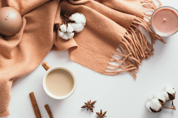 istock Autumn composition. Flat lay coffee cupm candles, brown scarf, cotton, cinnamon sticks, anise on white background. Hygge cozy home desk table. 1333573770