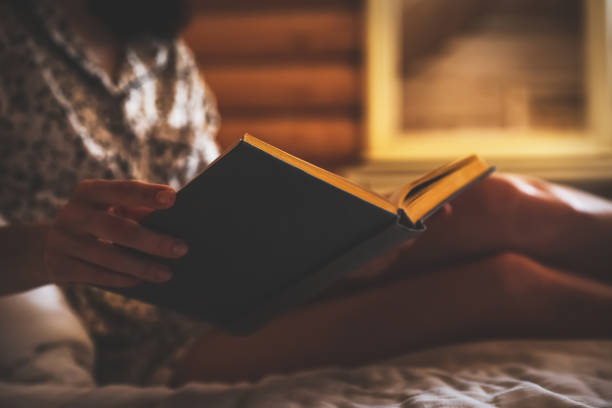 istock Woman reading book on bed at home, closeup 1333575320