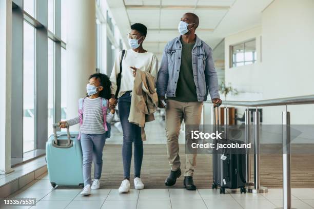 Tourist Family Walking Through Passageway In Airport Stock Photo - Download Image Now