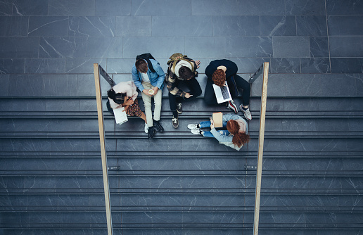 Estudiantes sentados en el campus universitario photo