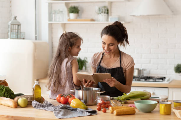 istock Mother reading to adorable daughter on kitchen 1333579590