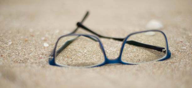 istock Blue rimmed glasses on the sand. 1333584516