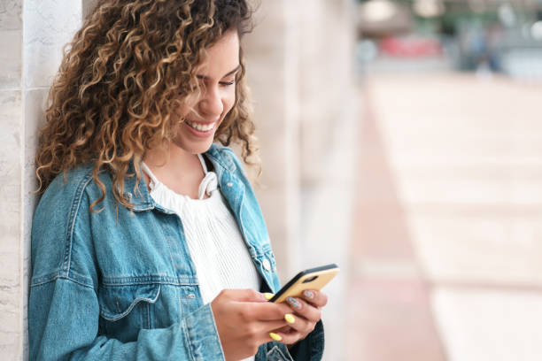 istock Young woman using her mobile phone outdoors on the street. 1333586438