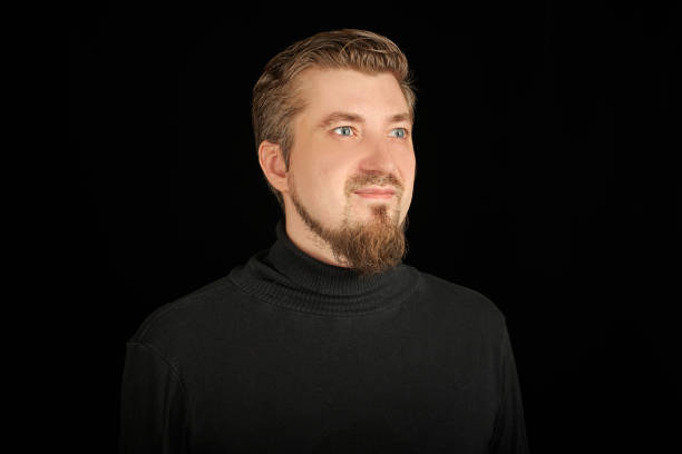 istock Cute bearded man, half-profile portrait, black background 1333586752