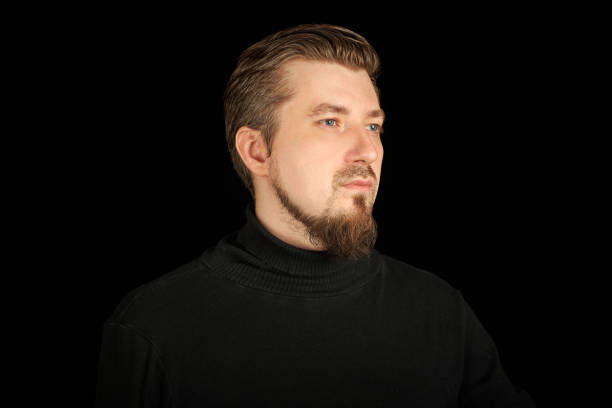 istock Cute bearded man, half-profile portrait, black background 1333586776